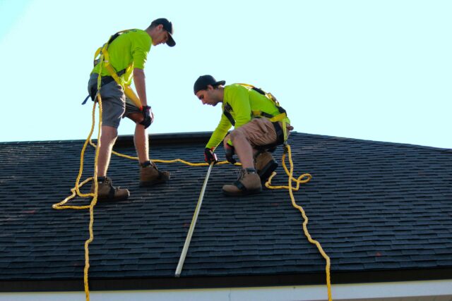 The Shingle Master workers repairing a roof.